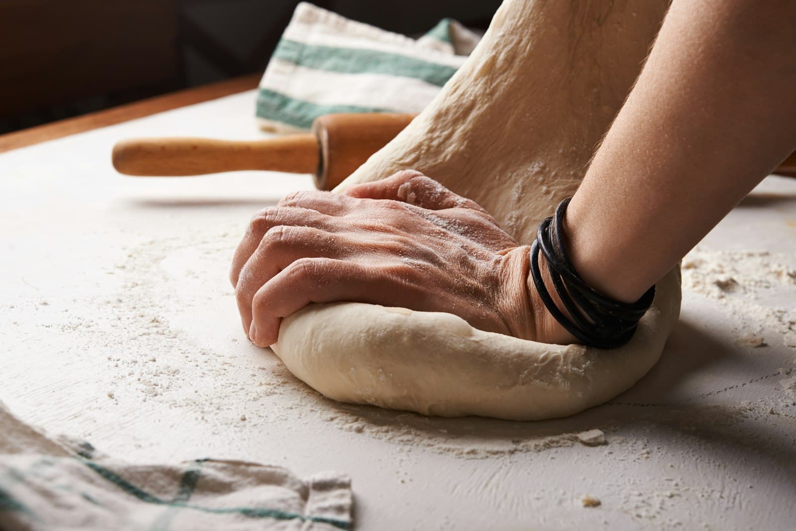 Baker kneading fresh dough by hand