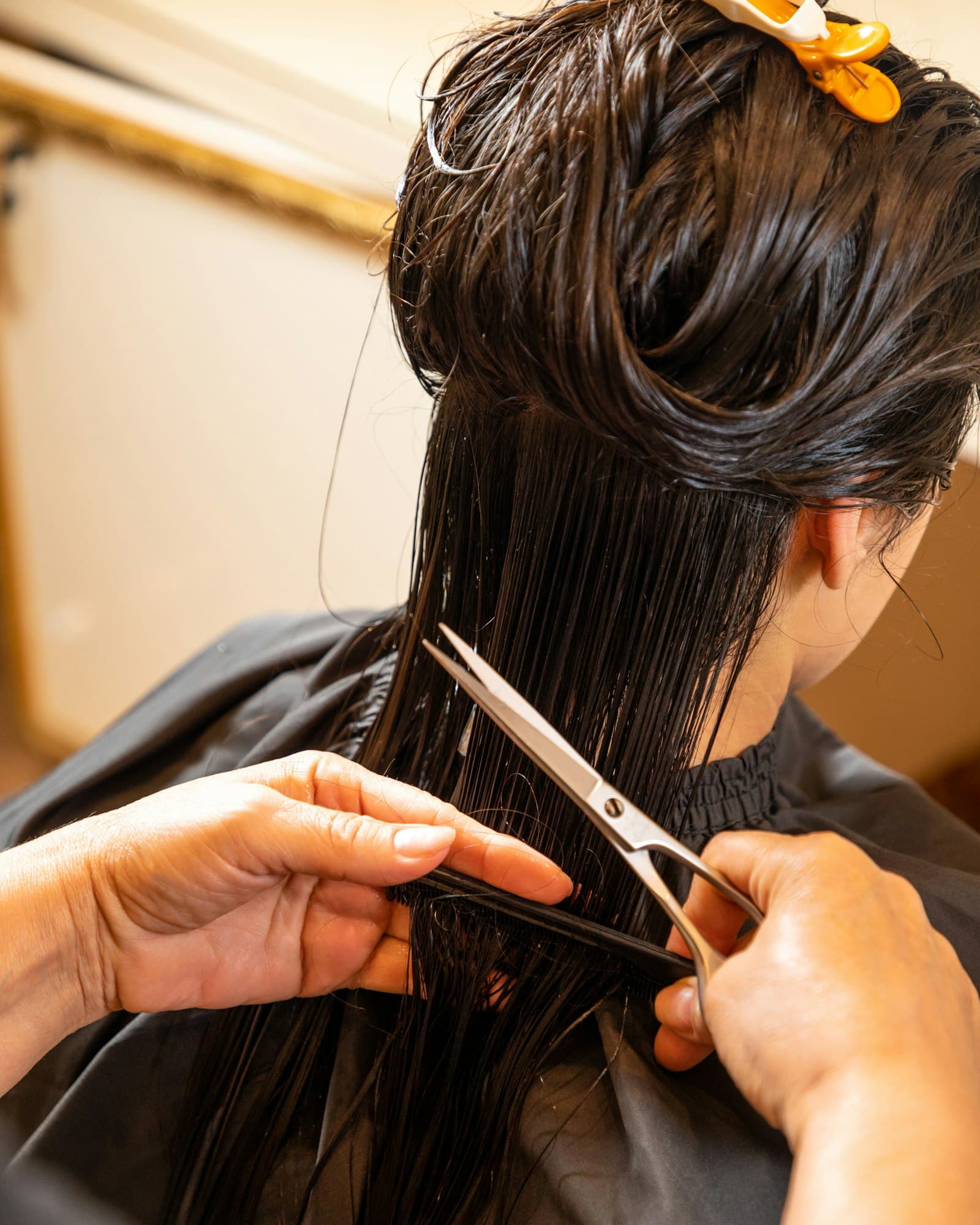Hairstylist trimming a client's hair with scissors